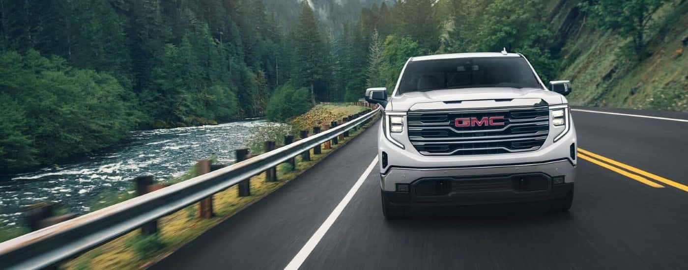 White 2024 GMC Sierra 1500 driving on a highway