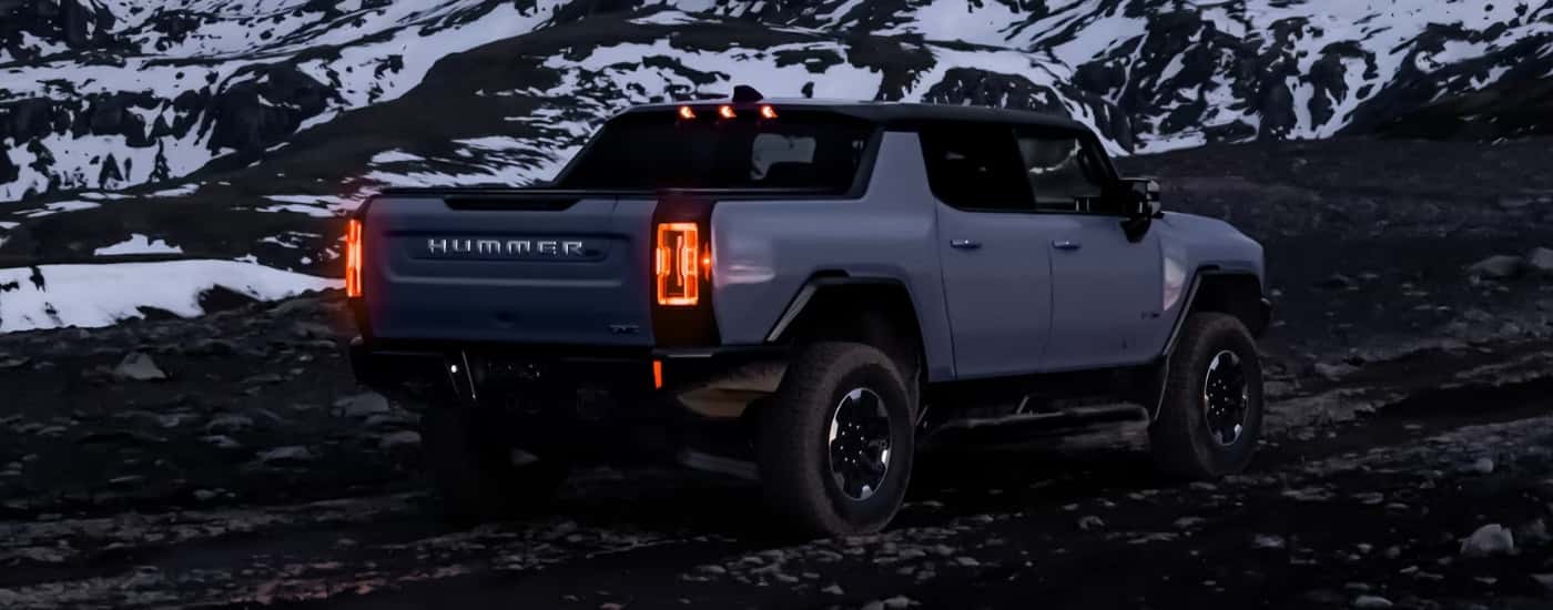 Grey 2025 GMC Hummer EV driving on a trail