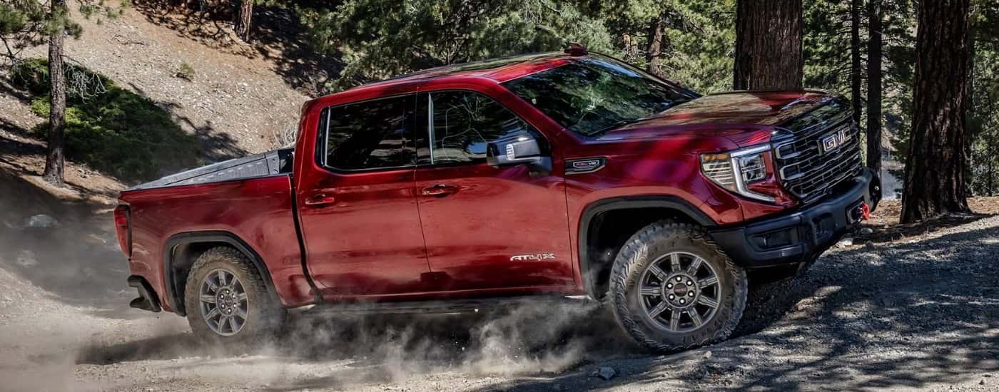 Red 2025 GMC Sierra 1500 AT4X driving on a trail