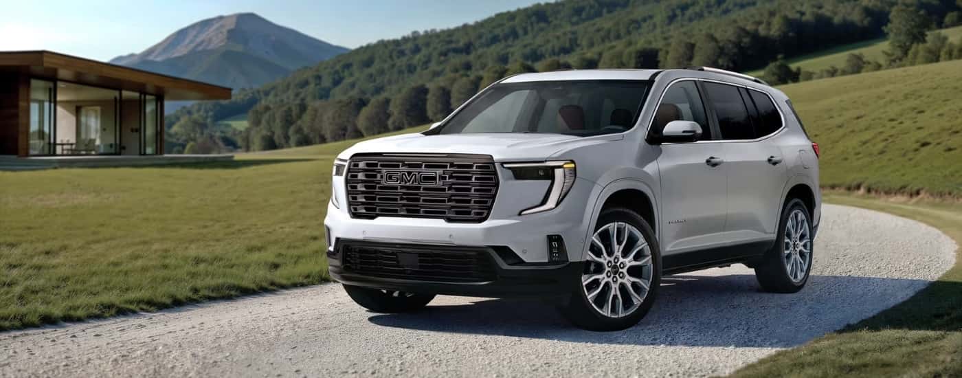White 2026 GMC Acadia Denali parked on a driveway.