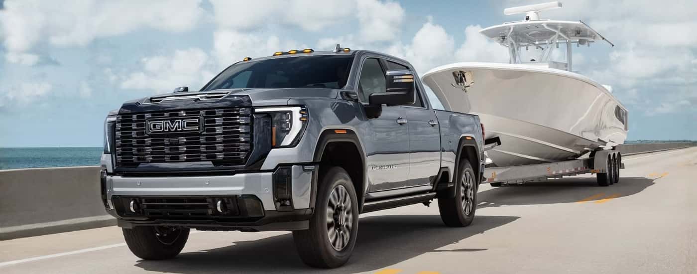 Grey 2026 GMC Sierra 2500 HD Denali towing a boat