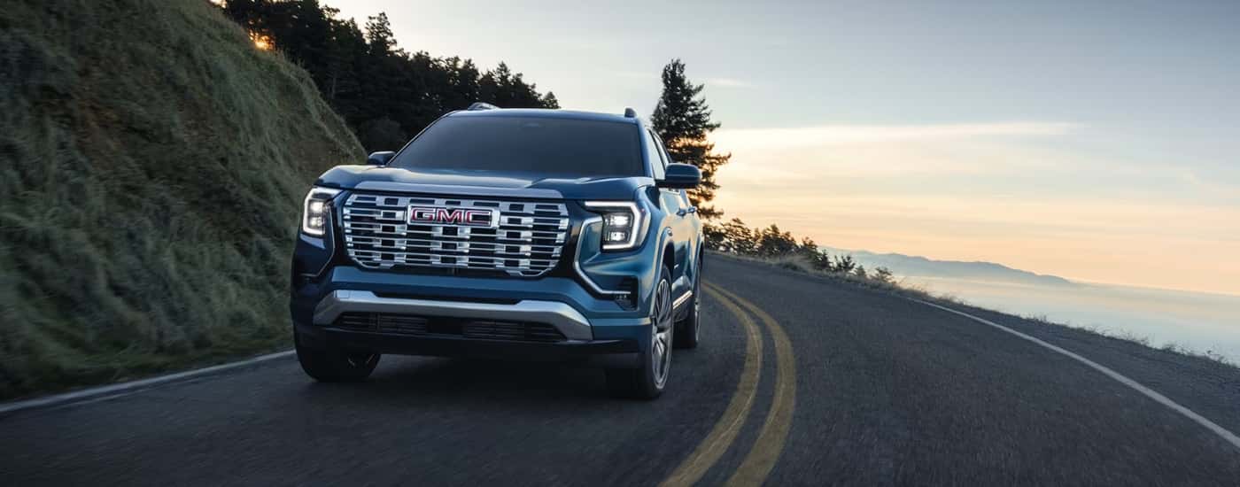 Blue 2026 GMC Terrain for sale driving on a highway