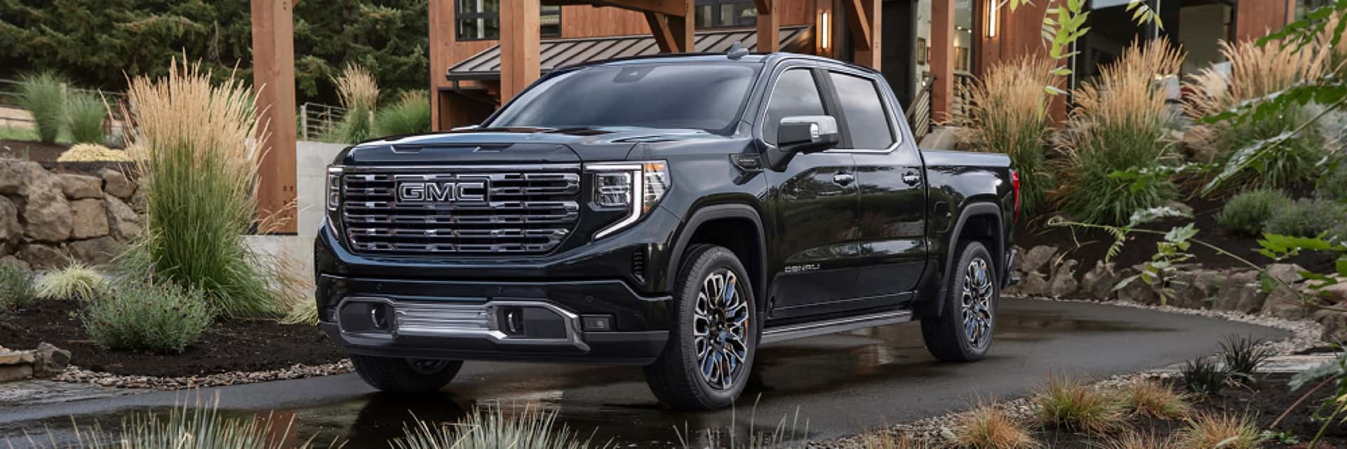 GMC-truck-parked-in-front-of-house-with-landscaping-grasses-in-the-driveway