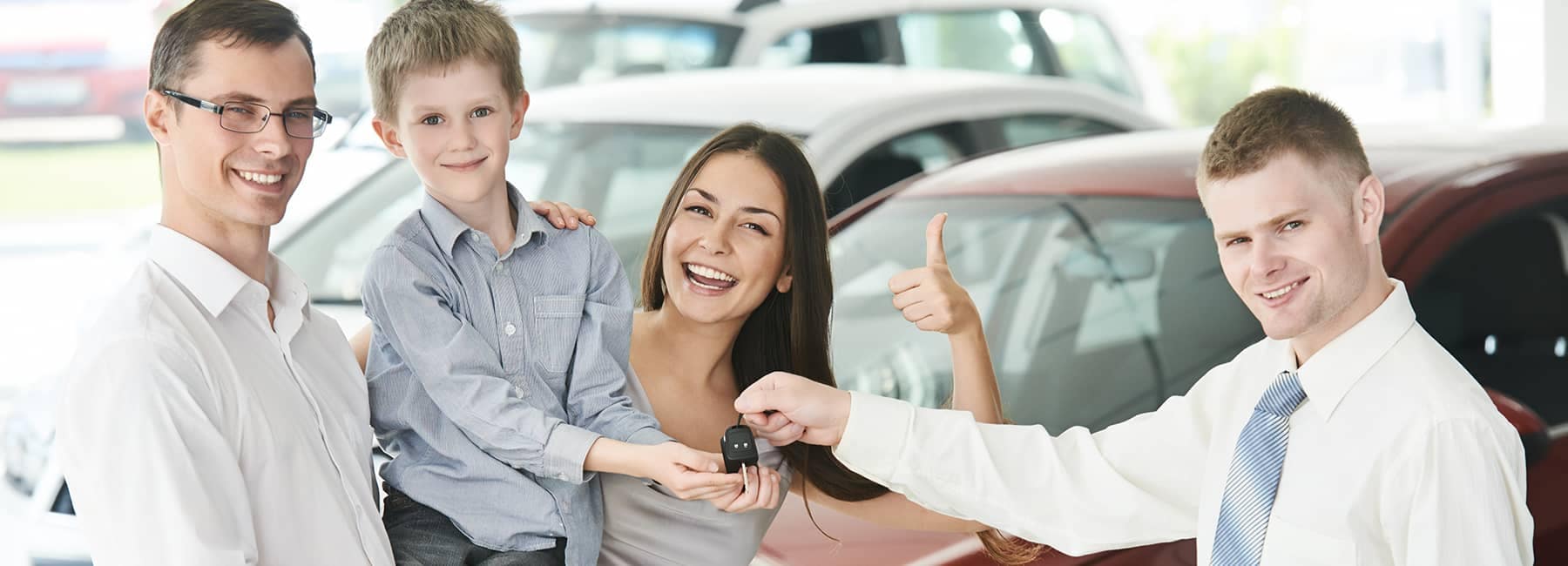 salesman handing car keys to smiling family