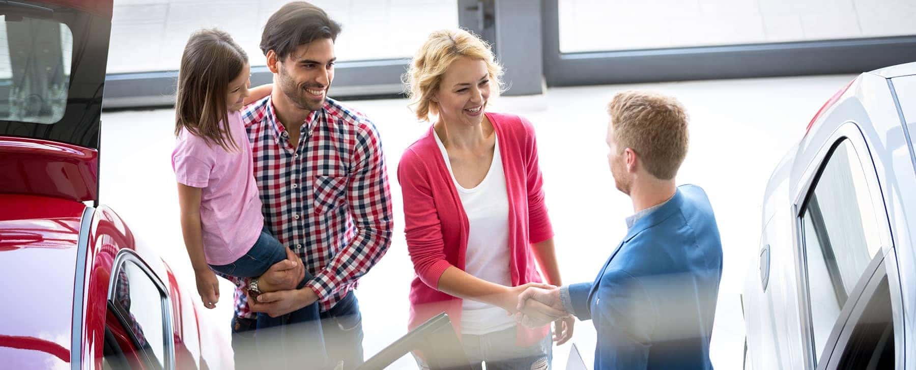 A family inside of a dealership showroom