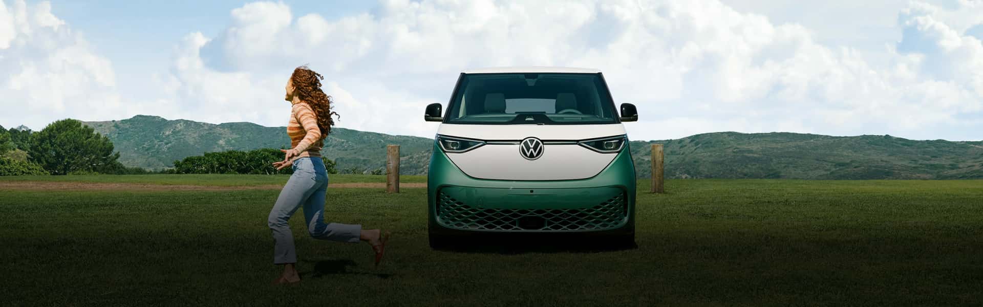2024-VW-ID-Buzz-in-a-green-field-with-woman-running-past