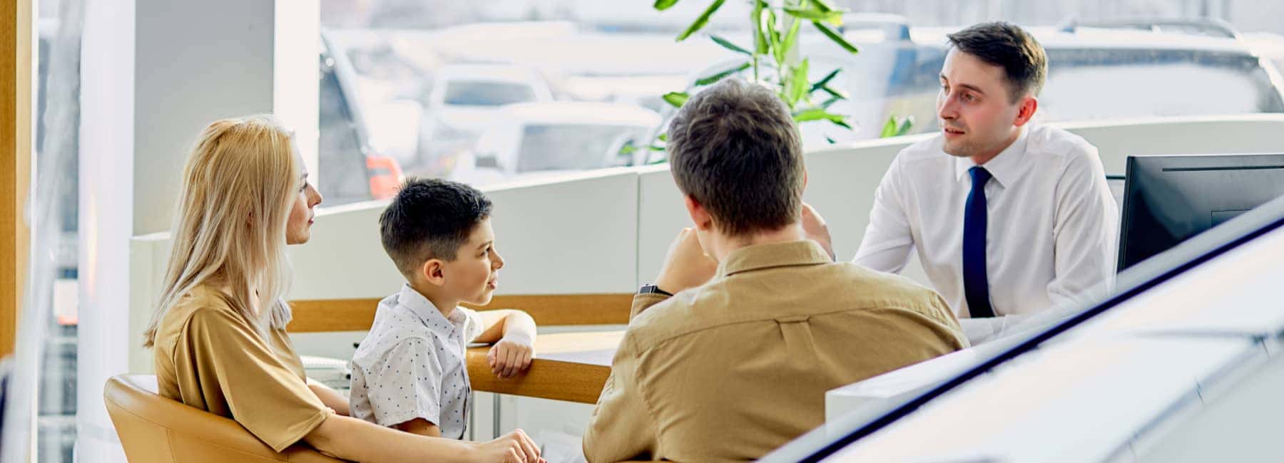 A family sitting with a finance advisor at a dealership