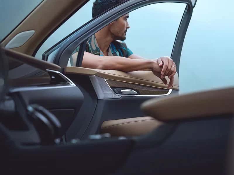 man leans against open window