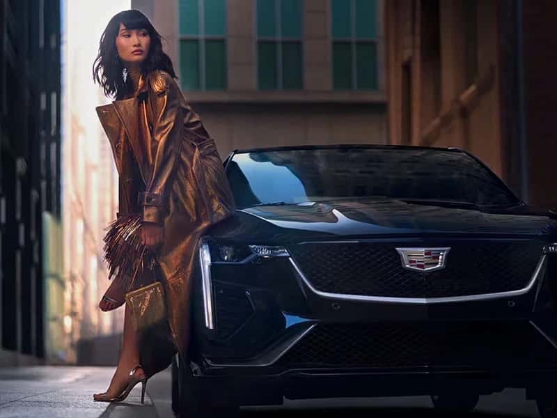 women in coat sitting on Cadillac