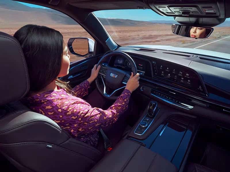 women driving Cadillac