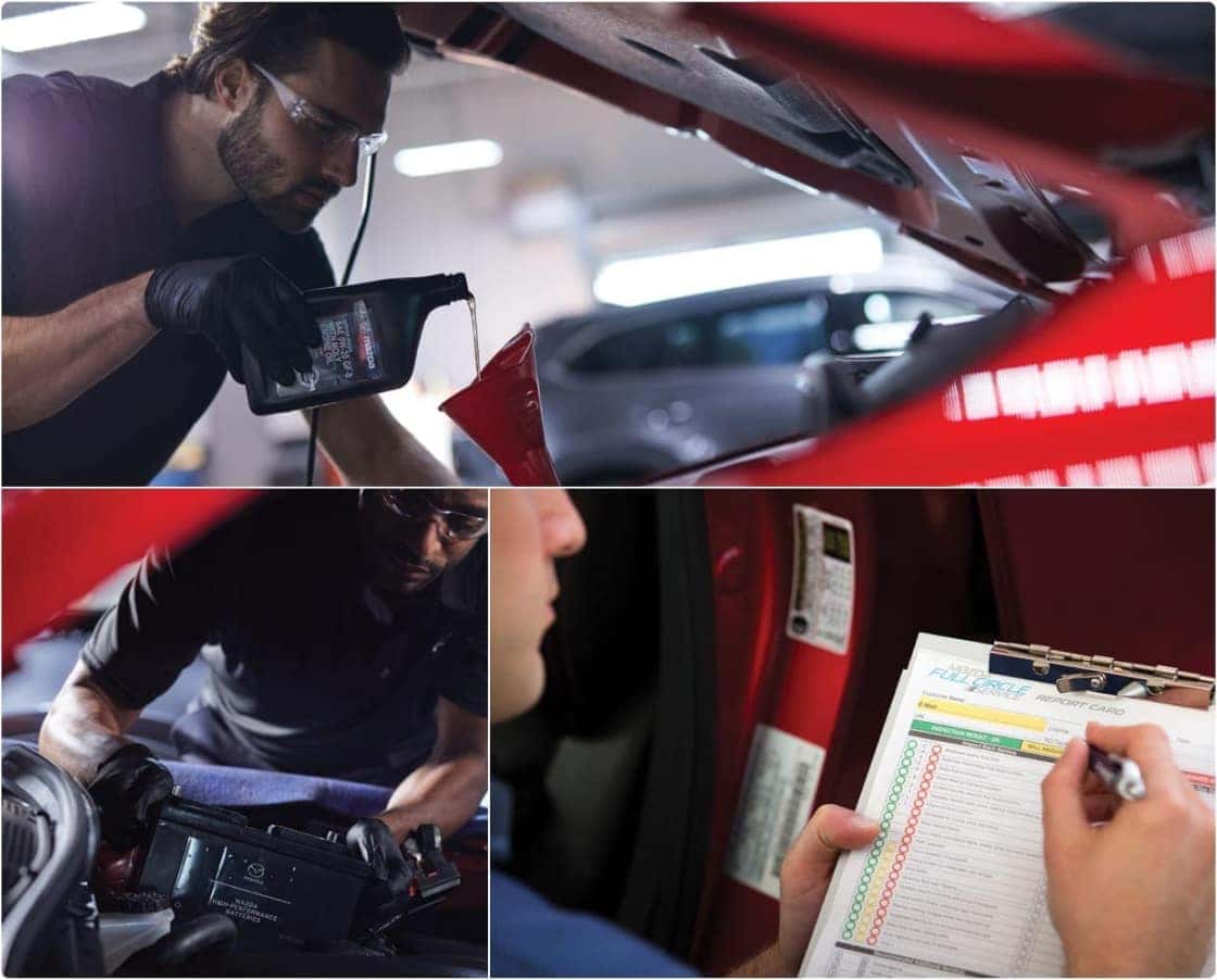 Service technicians working on a red Mazda