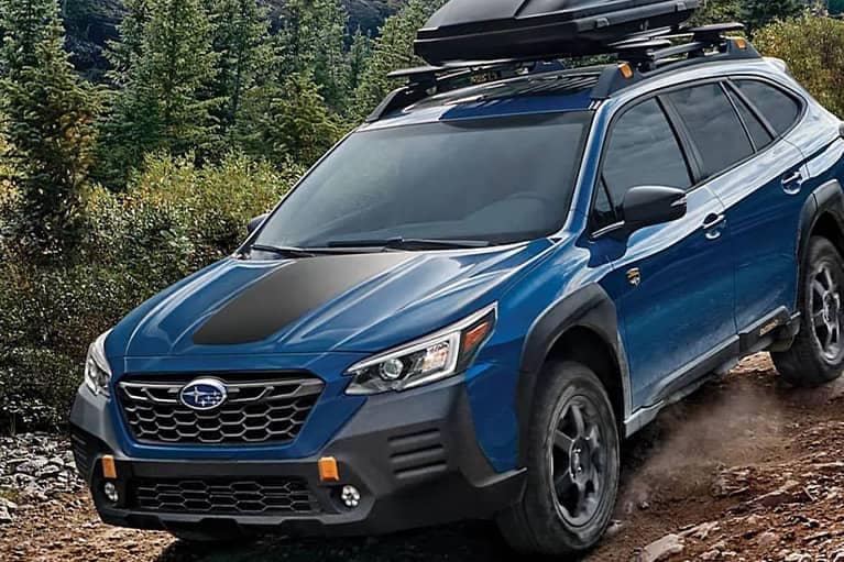 2022 Subaru Outback- front 3qview-driving down rocky forest trail-blue black
