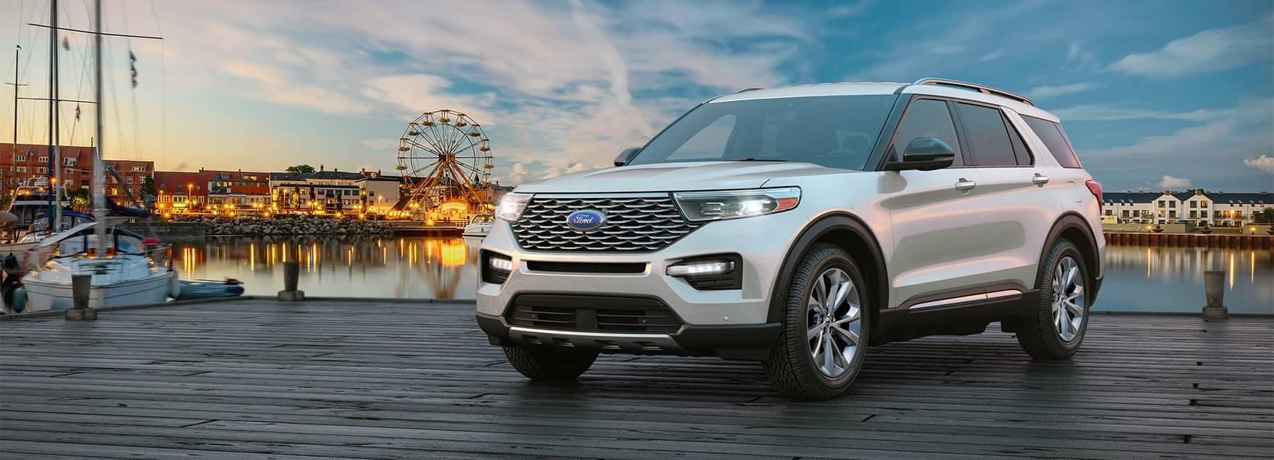 White 2021 Ford Explorer parked on a boardwalk with a ferris wheel in the background