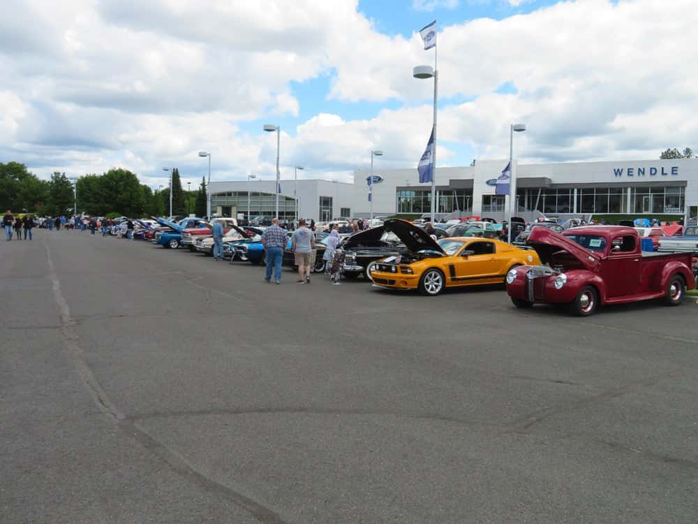 People standing around a white car