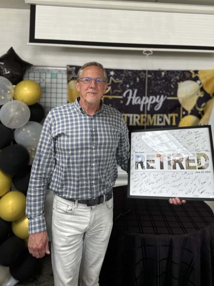 A man standing in front of a sign