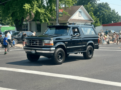 A black car drving on a street
