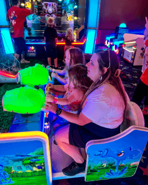 A person and two children playing arcade games