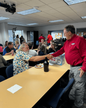 A person shaking hands with a person at a table