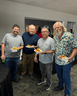 A group of men holding plates of food