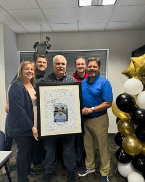 A group of people holding a framed picture