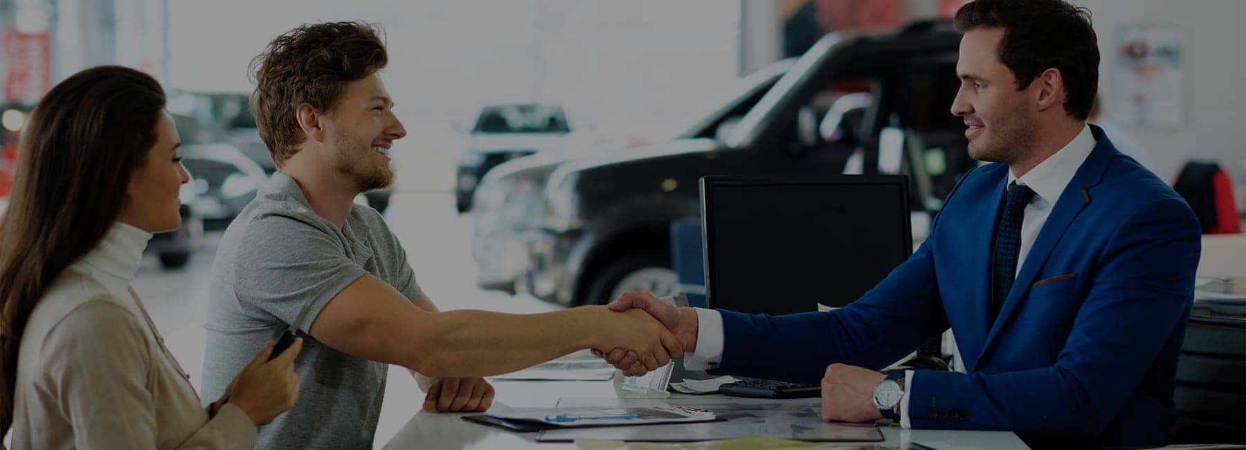 A-customer-and-a-car-salesman-shake-hands-after-a-car-purchase-desktop