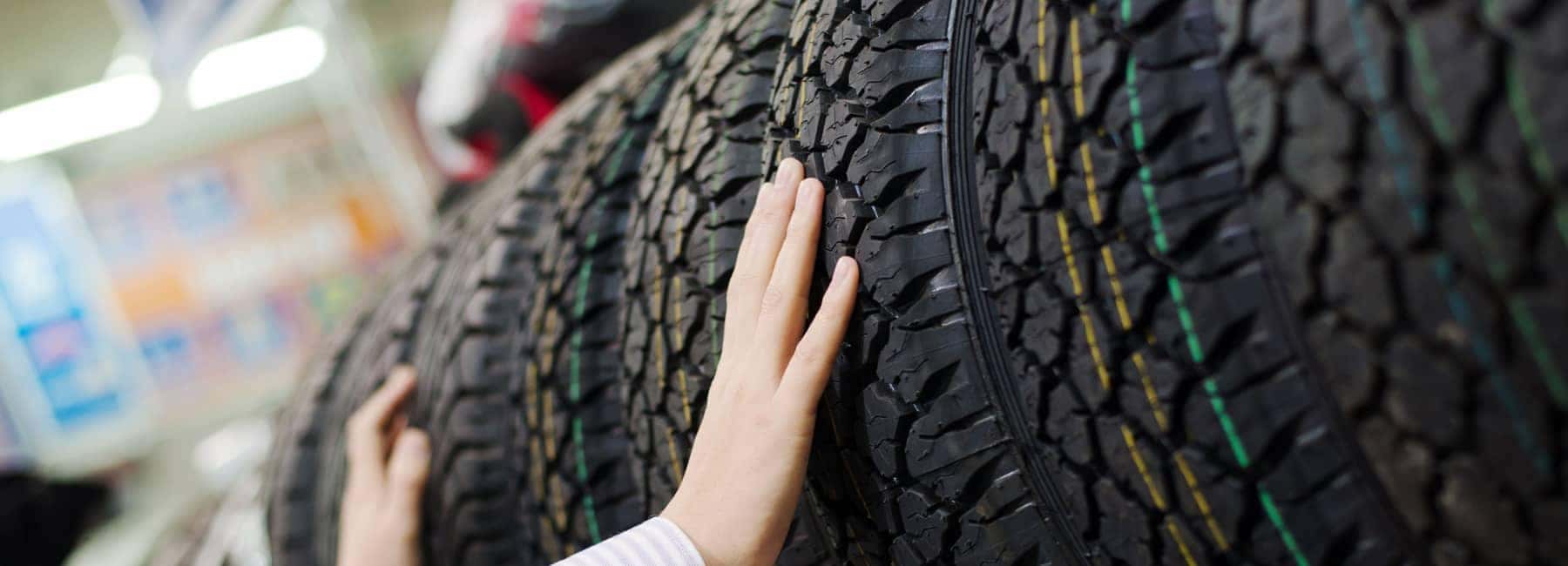 Hands Inspecting Tires in a Tire Store