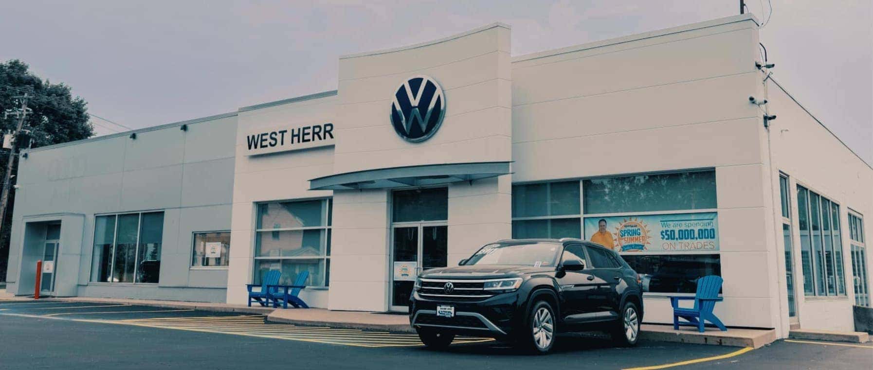 Front doors of dealership with black SUV 