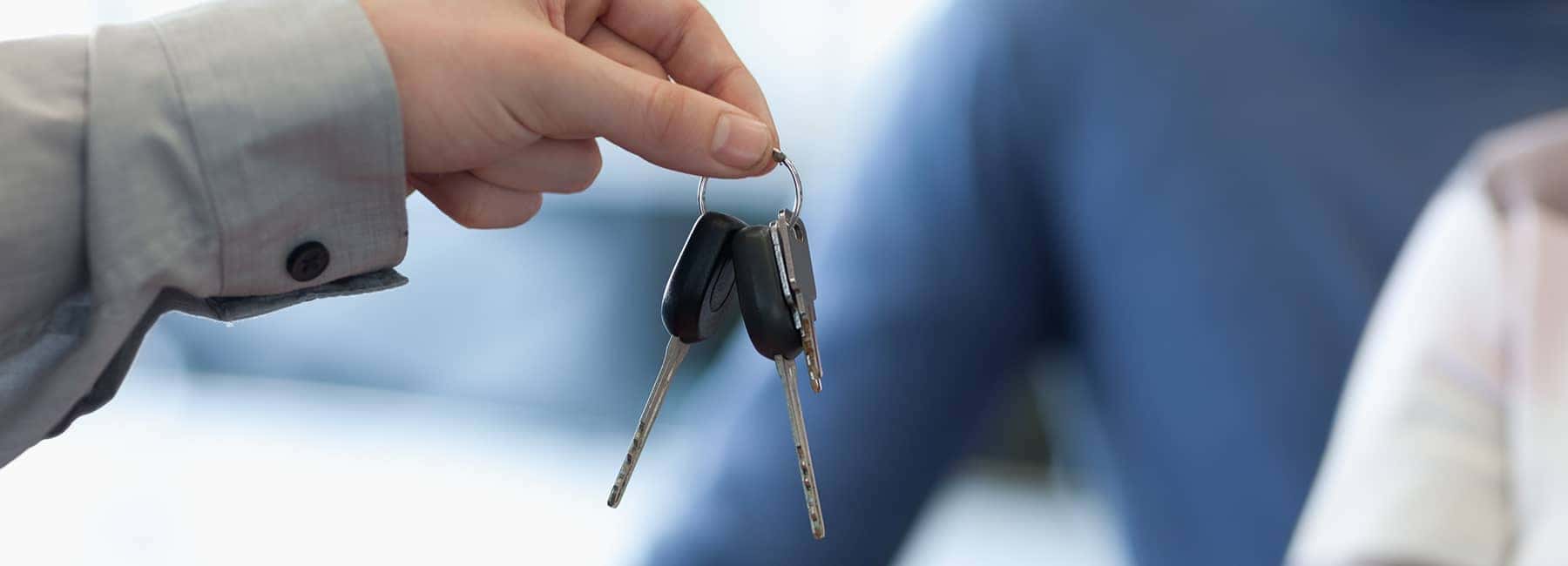 man handing car keys to couple