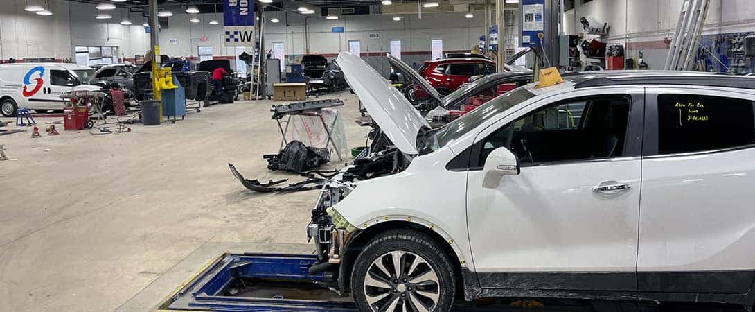 car hoods up all in a row in body shop