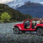 Image of a red 2019 Jeep Wrangler parked by a river.