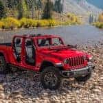 Image of a red 2020 Jeep Gladiator parked near a stream.
