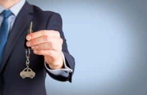 Man Holding Up Car Key with Car Keychain