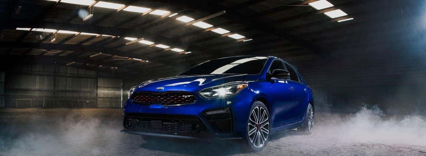 Blue Kia Sedan driving through a dark and smokey tunnel