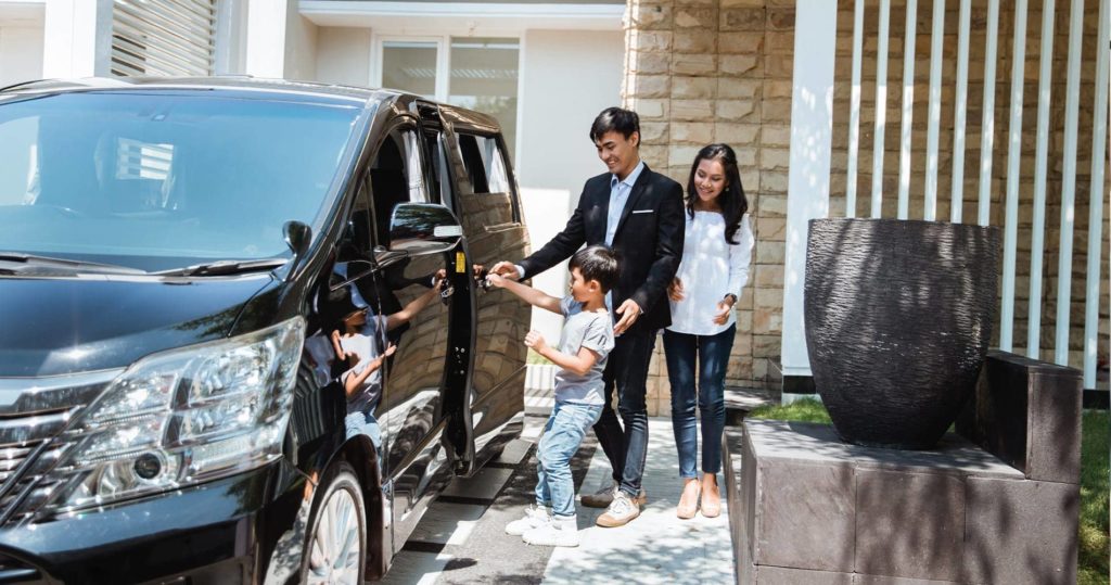 Two parents and a child opening the door to their van