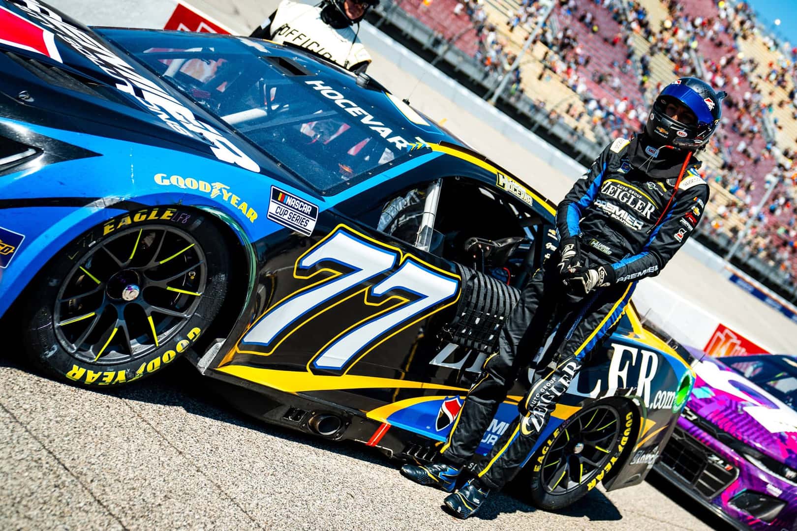 Carson-Hocevar-poses-with-the-Zeiglerdotcom-77-Camaro-at-the-2024-Firekeepers-Casino-at-Michigan-International-Speedway-scaled